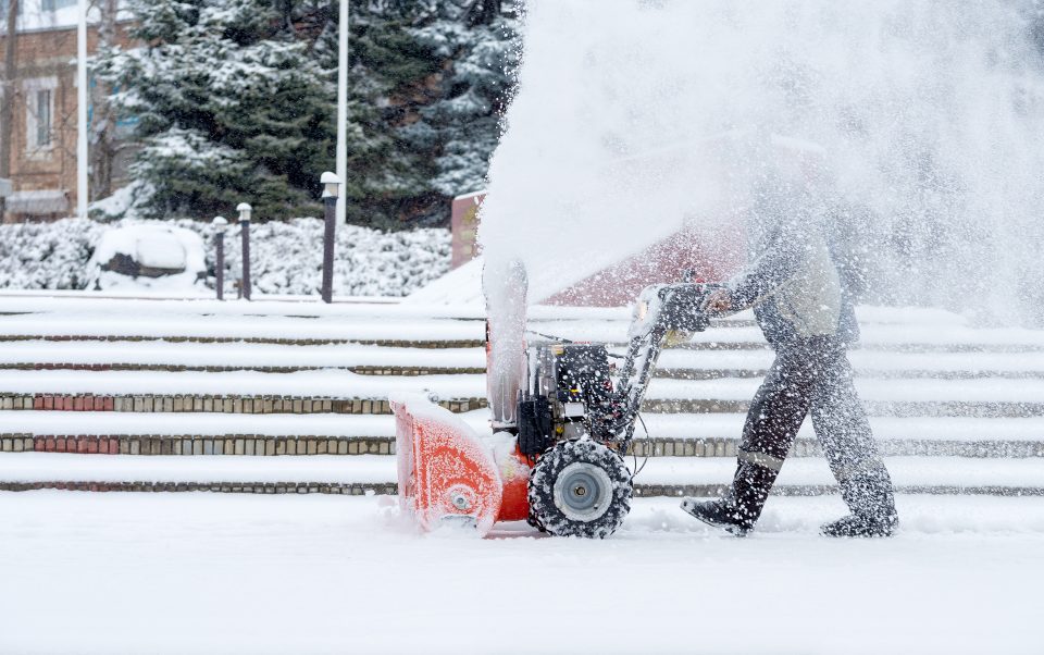 man using snowblower to clear snow off of property