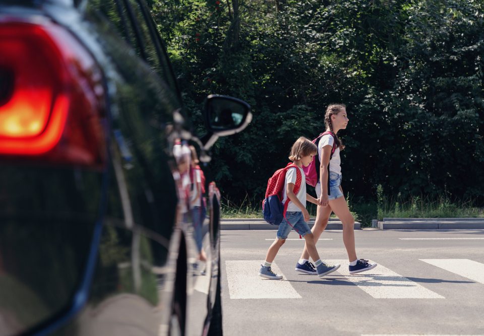 two kids crossing at a crosswalk