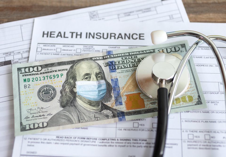 health insurance paperwork with a $100 and stethoscope