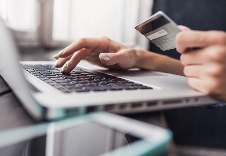 person typing in credit card information on a laptop